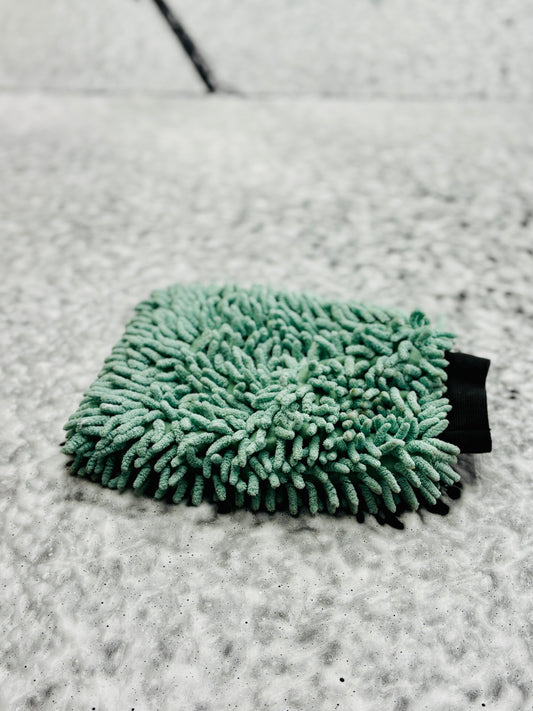 Wash mitt on a foamy vehicle hood surface